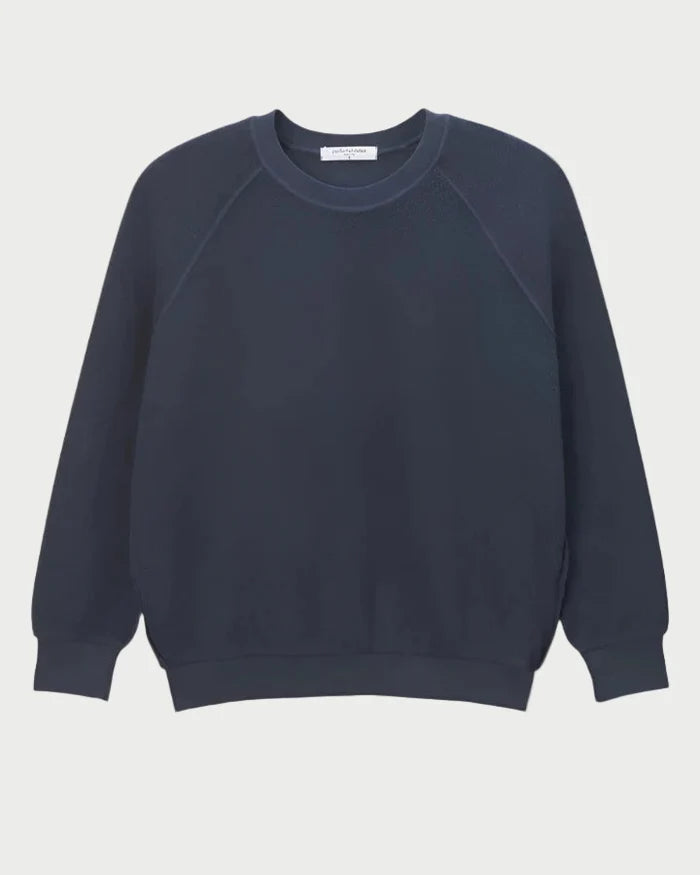 The Perfectwhitetee Ziggy Sweatshirt in navy by perfectwhitetee features a crewneck, long sleeves, and ribbed cuffs in an inside-out fleece style, shown on a white background.