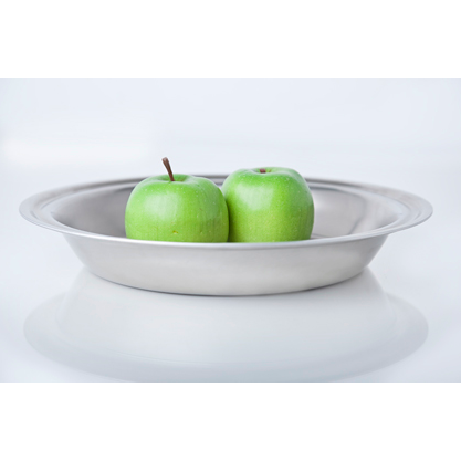 Front view of 9-inch stainless steel pie pan showing shallow depth and rolled rim with two green apples on a white surface