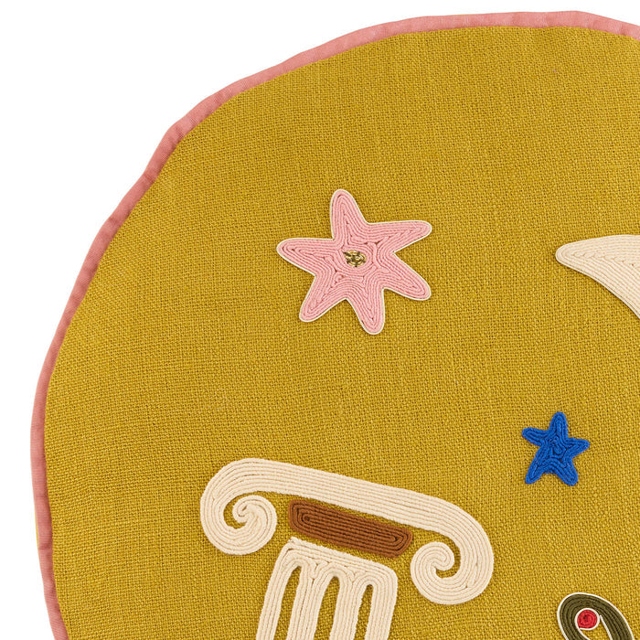 Close-up of a yellow cushion with decorative elements including a starfish, column, and star on a white background.