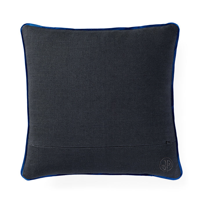 A square dark gray textured throw pillow with a vibrant blue piping border and a small circular embroidered monogram logo in the bottom right corner, set against a plain white background.