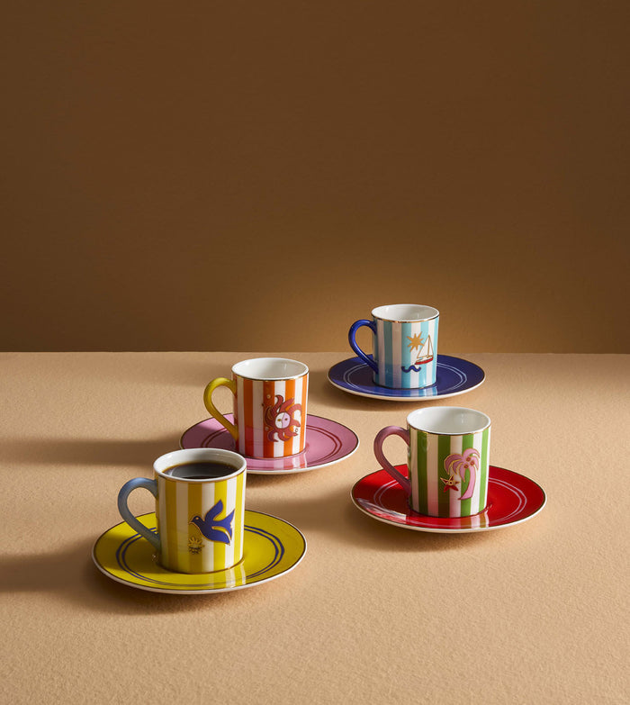 Set of colorful coffee cups and saucers on a beige surface with a brown background