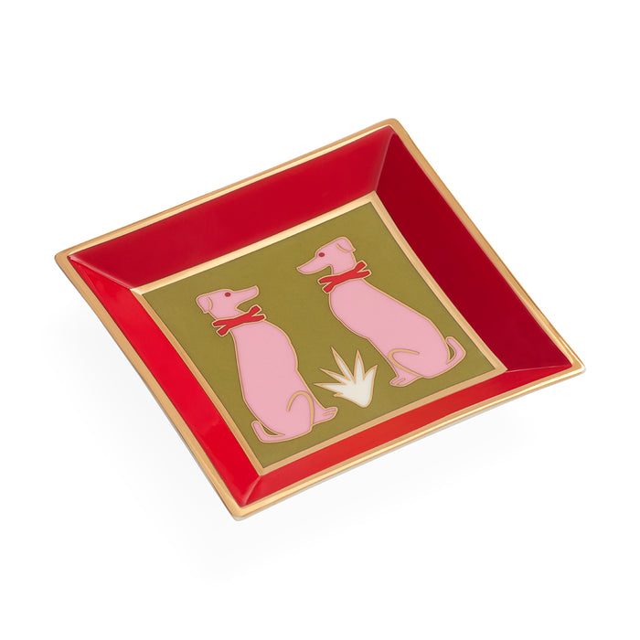 A square ceramic dish with a glossy red interior, a gold rim, and a central olive-green panel featuring two pink dogs wearing red bows on a white background.