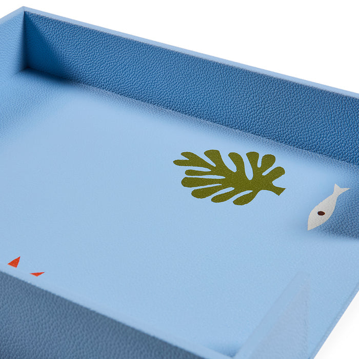 Blue tray with green leaf and white fish design on a light blue background