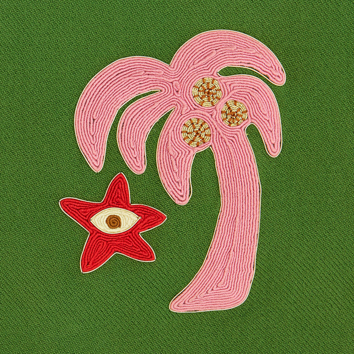 Embroidered design of a palm tree and starfish on a green fabric background