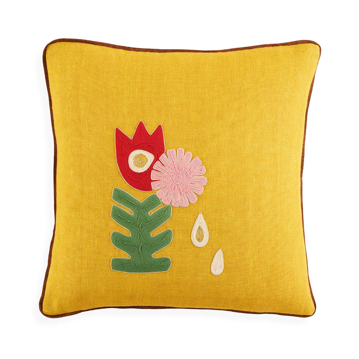 Yellow pillow with floral embroidery on a white background