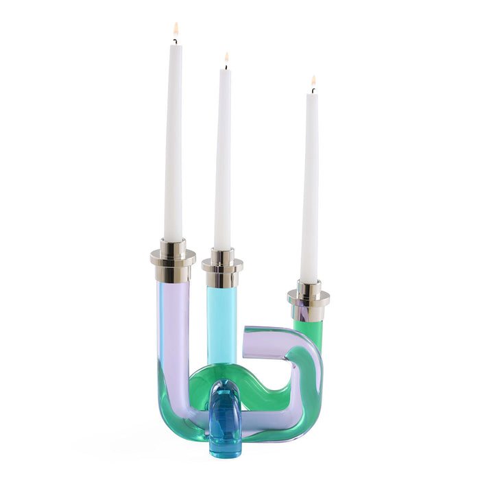 Colorful glass candle holder with three white candles on a white background