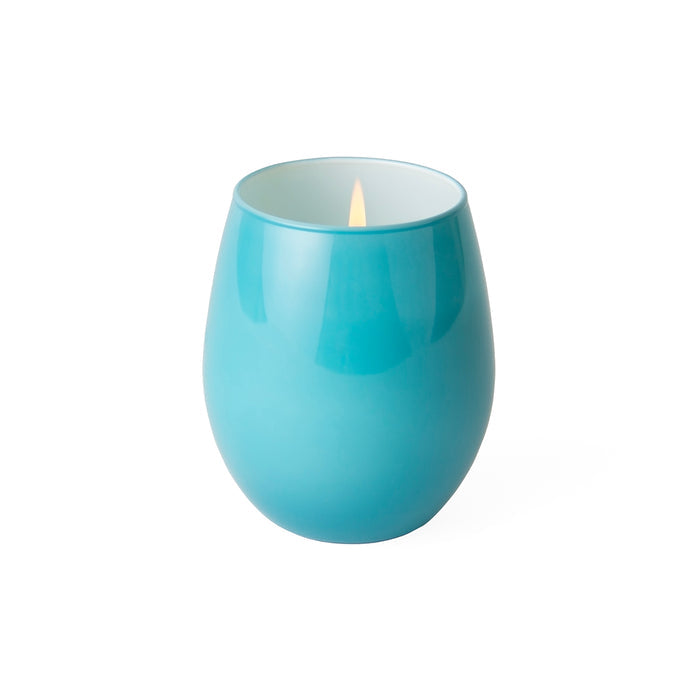 A glossy teal blue ceramic candle holder with a lit candle inside, set against a plain white background.