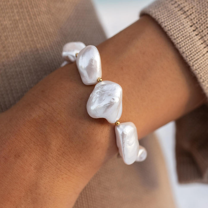 Close up of a chunky white pearl bracelet on a womans wrist
