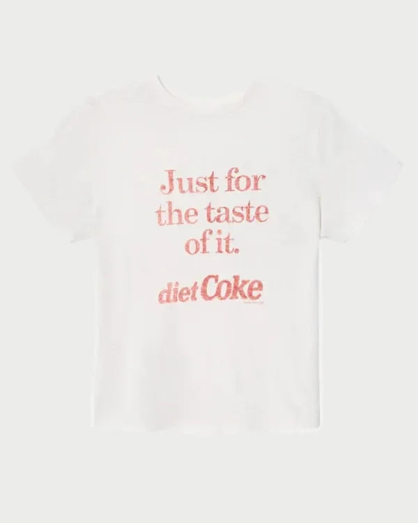 The RE/DONE Diet Coke Classic Tee by RE/DONE is a white t-shirt featuring red text on the front that reads, "Just for the taste of it. diet Coke," displayed against a plain white background. Vintage-inspired and crafted from relaxed fit cotton, this Coca-Cola graphic tee combines casual comfort with classic style.