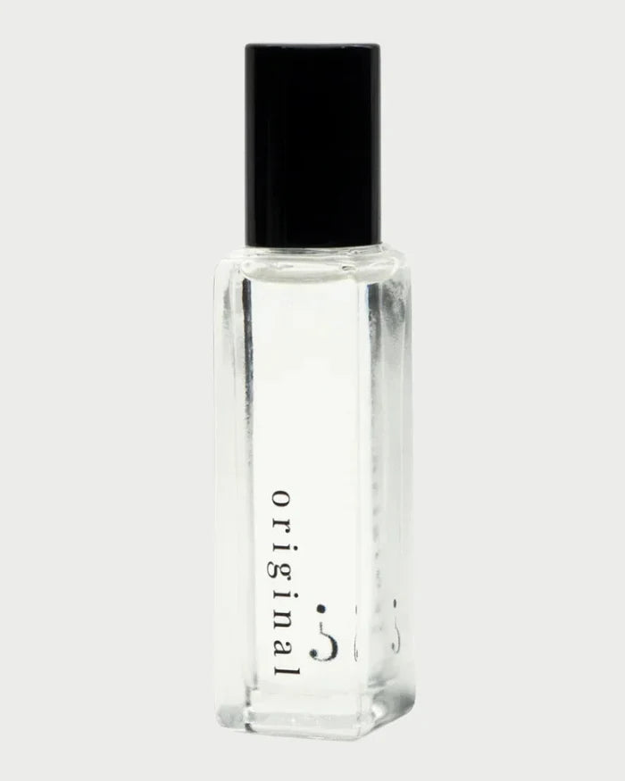 The Riddle Roll-On Oil in Original 20ml by Riddle Oil features a clear glass bottle with a black cap, labeled "original" in lowercase letters on the side. Celebrated for its natural scent and understated charm, this sleek and sophisticated bottle has developed a devoted fan base. It sits against a plain, light background.