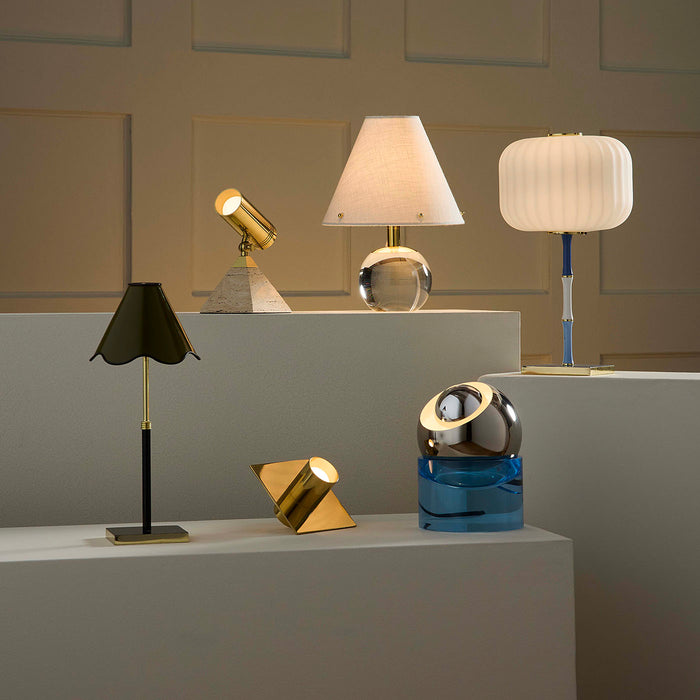 Collection of various table lamps on a gray surface with a neutral background