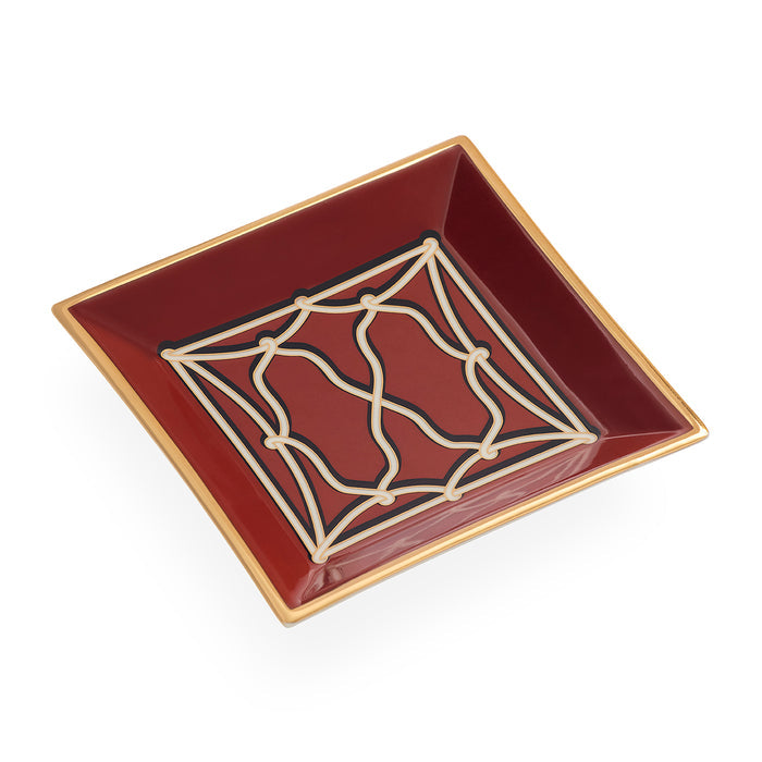A square ceramic dish in deep burgundy with a gold rim and a cream-colored geometric lattice pattern on the inside, shown on a plain white background.