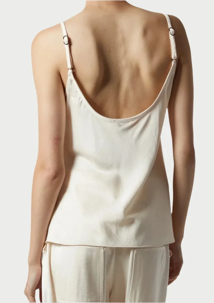 A person is shown from the back wearing the Saint Art Elliot Ivory Charmeuse Camisole by Saint Art NY, featuring adjustable straps and a low scooped back, paired with matching pants against a plain, neutral background.