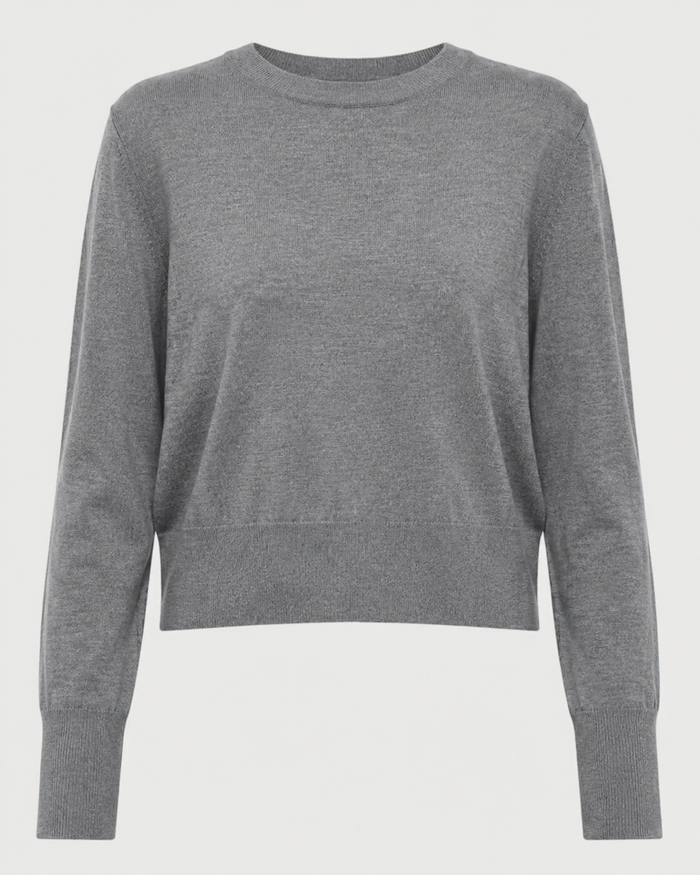 The Saint Art Elodie Sweater by Saint Art NY is a lightweight women’s crew neck sweater in grey, featuring long sleeves with ribbed cuffs and waistband, crafted from soft merino wool and shown against a white background.
