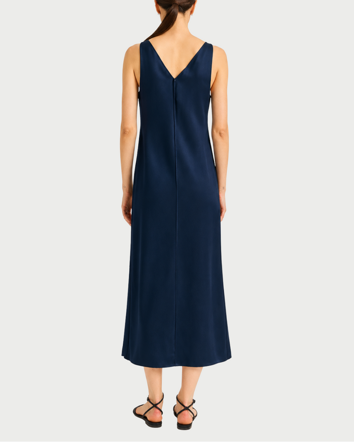 Woman wearing a navy blue dress with a V-neckline on a white background