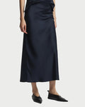 Person wearing a black slip dress on a white background