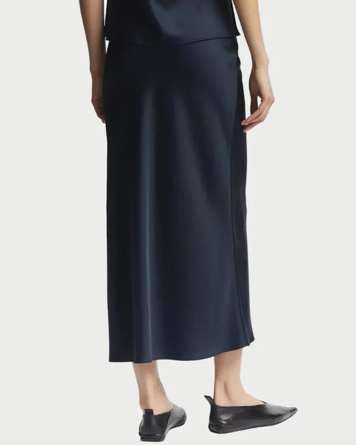Person wearing a black slip dress on a white background