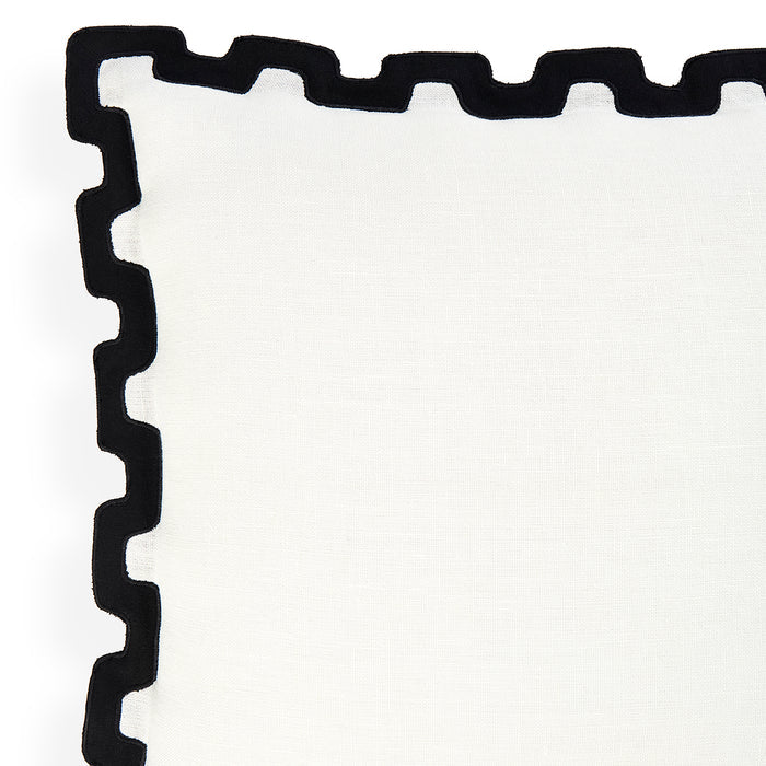 A close-up of a white textile product, likely a napkin or table linen, featuring a thick black scalloped or wavy border along one corner.