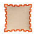 A square throw pillow with a textured beige linen-like center and a bright orange interlocking puzzle-style border, shown on a plain white background.