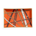 A rectangular ceramic serving tray with a vibrant orange background and an illustration of overlapping leather straps in brown, tan, and white, finished with a light beige rim.