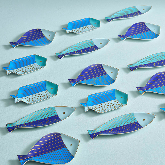 Collection of fish-shaped ceramic dishes on a light blue background