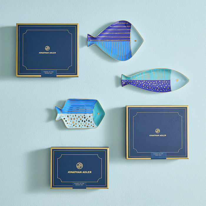 Set of Jonathan Adler fish-shaped decorative plates on a light blue background