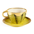 Gold and black patterned teacup and saucer on a white background