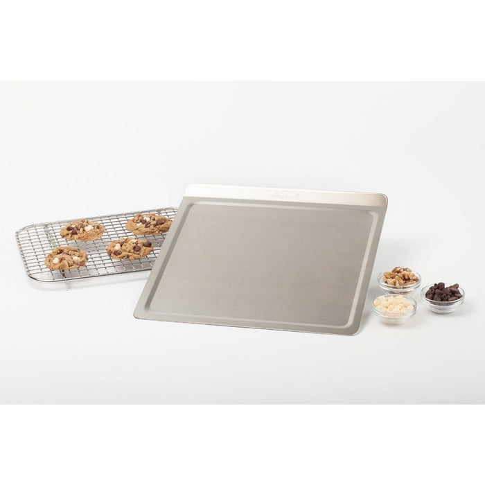 Half-sheet baking pan with cooling rack holding four chocolate-chip cookies and three small bowls of nuts and chocolate chips