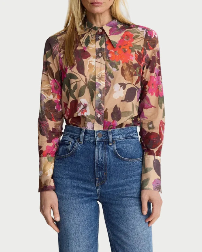 Woman wearing a floral blouse and blue jeans on a white background