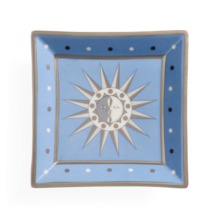 A square ceramic plate with a light blue center and a medium blue border, featuring a central sun and moon design with a cat's face. The plate is decorated with white and black dots along the border and has a gray rim.