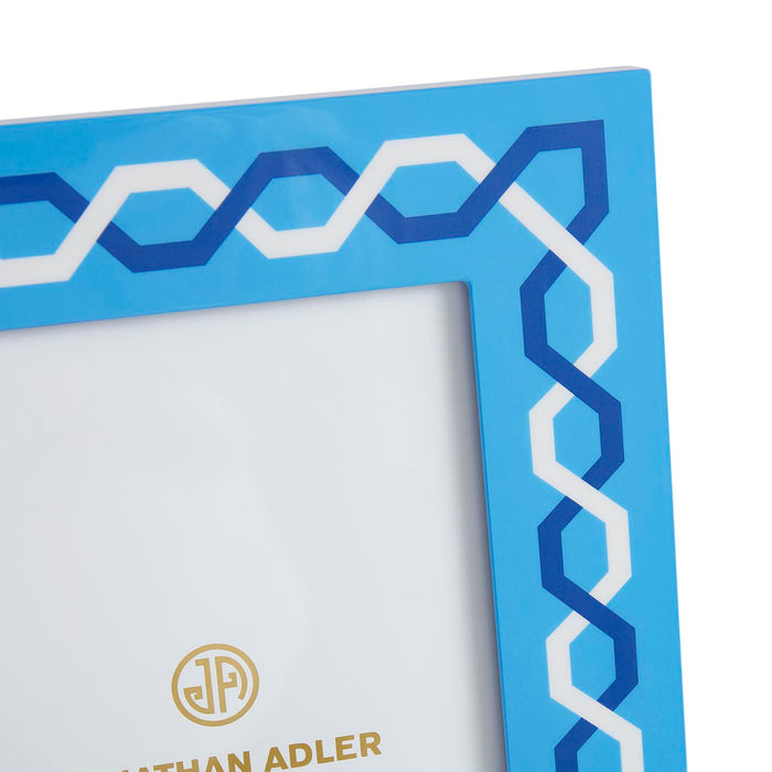 Blue decorative frame with white and blue geometric pattern, featuring the Nathan Adler logo.