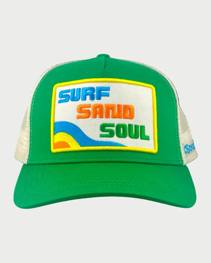 The Soulbyrd Surf Sand Soul Trucker Hat features green and white mesh, a vibrant "SURF SAND SOUL" patch with blue, orange, and green letters above a yellow wave, plus an adjustable snapback for a perfect fit.