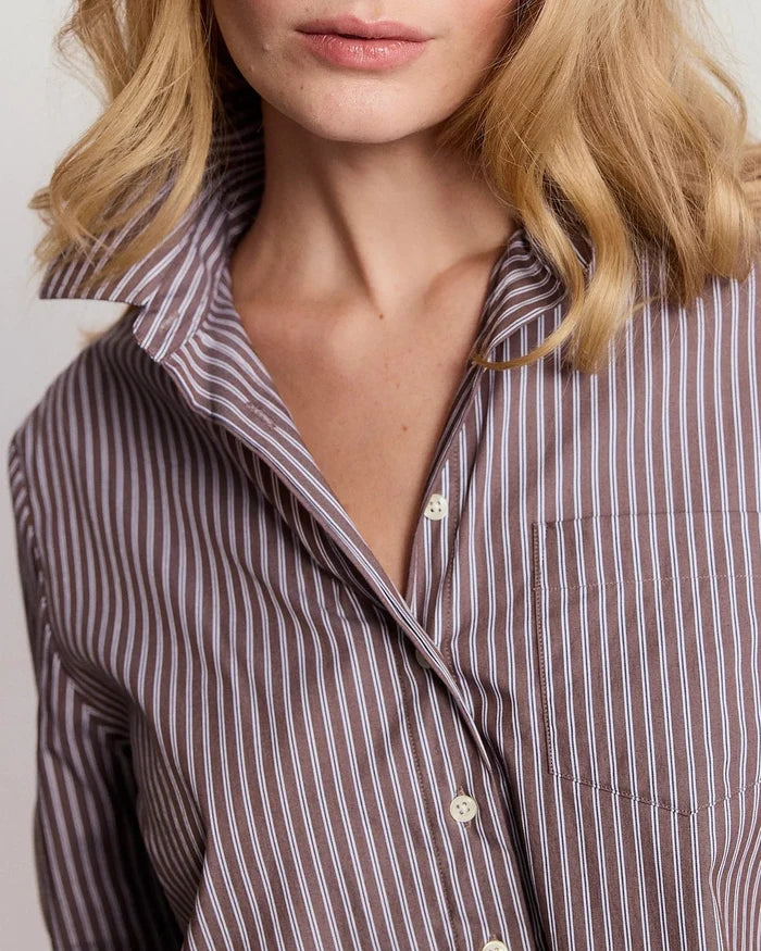Woman wearing a striped shirt against a plain background