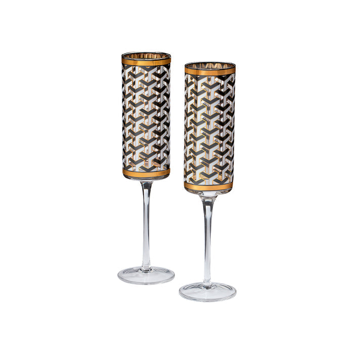 Two clear stemmed glasses with cylindrical bowls featuring a geometric interlocking cube pattern in black, white, and gold, set against a plain white background.