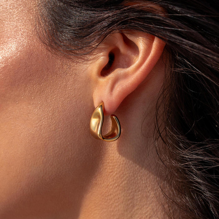 Gold triangle hoop earring with unique bends and indents