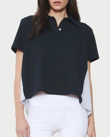 Woman wearing a black polo shirt, white shorts, and red sneakers with a white background