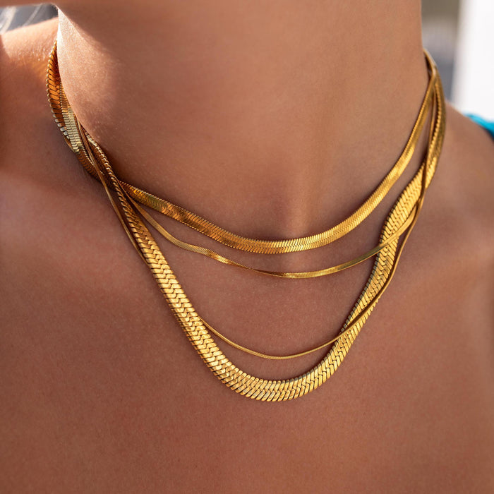 an everyday necklace stack with four gold necklaces of the same herringbone pattern in different sizes